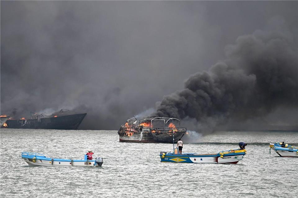 Im Hafen von Manta stehen mehrere Fischerboote in Flammen.Ariel Ochoa/AP/dpa