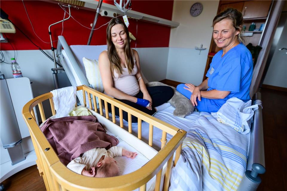 Im Klinikum Lüneburg werden Verena Ahrens und ihre wenige Tage alte Tochter von Hebamme Franziska Pfeil (r) betreut. Pfeil hat die erste Geburt im neu eröffneten hebammengeleiteten Kreißsaal im Klinikum Lüneburg betreut.Philipp Schulze/dpa