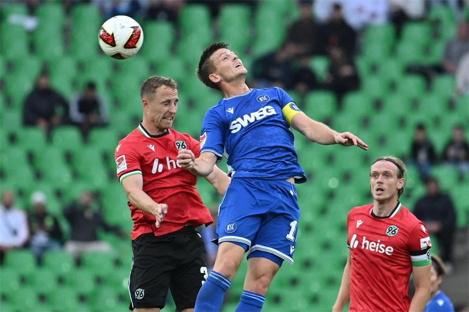 Im Kopfballduell: Karlsruhes Marvin Wanitzek (r) und Maurice Neubauer von Hannover 96.Swen Pförtner/dpa