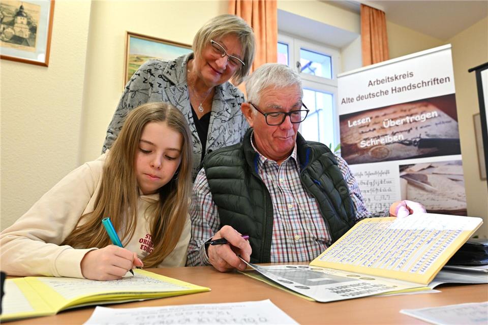 Im Sütterlin-Kurs lernen Enkelin Tamara und Großvater Heinrich Heckeroth zusammen, die alte Schrift auf das Papier zu bringen. Dozentin Birgit Tröße kontrolliert das Geschriebene.  Martin Schutt/dpa