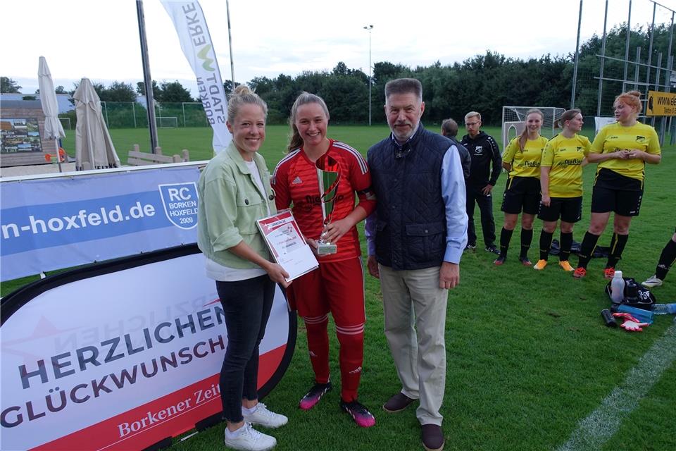 Im Vorjahr überreichten Lisa Schlattmann (links, vom Sponsor Borkener Zeitung) und der SSV-Vorsitzende Josef Nubbenholt den Siegerpokal an die Marbecker Spielführerin Jana Hölter.