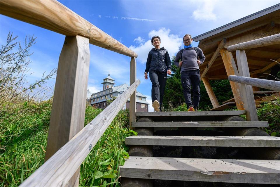 Im Wanderoutfit sind Claudia Brödner und Ronny Schwarz vom Tourismusverband Erzgebirge auf dem Gipfel des Fichtelbergs unterwegs. Hendrik Schmidt/dpa