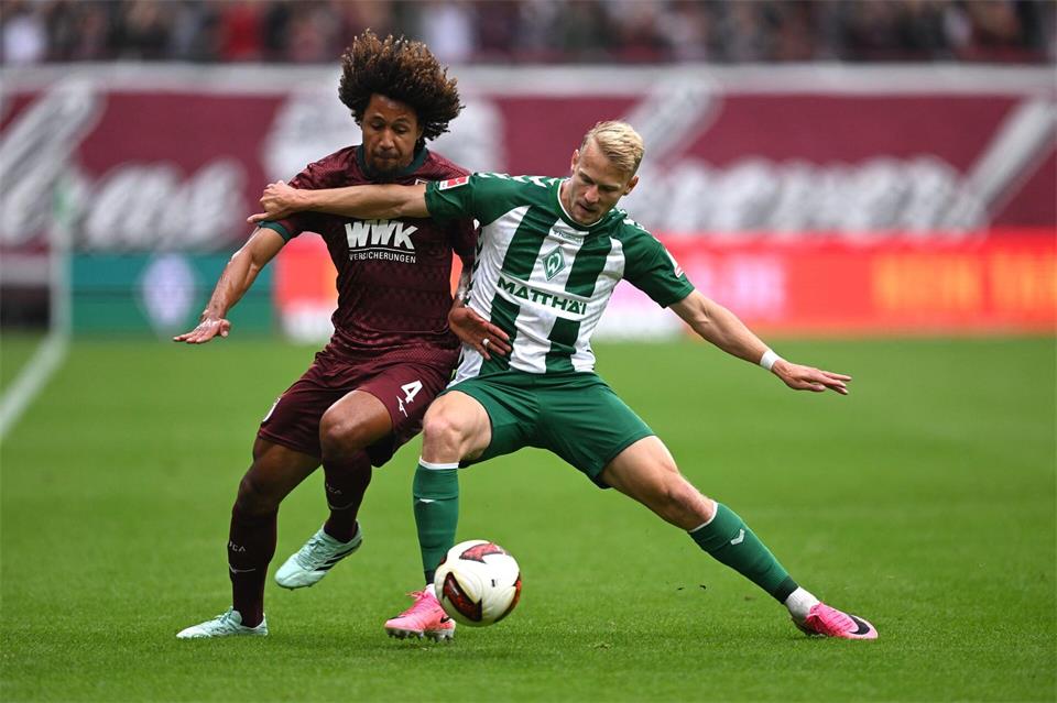 Im Zweikampf: Han-Noah Massengo vom FC Augsburg (l) und der Bremer Marco Grüll.David Inderlied/dpa