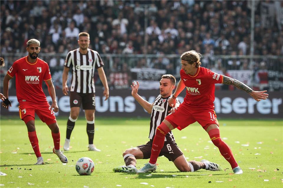Im Zweikampf: Kristijan Jakić vom FC Augsburg (r) und St. Paulis James Sands.Christian Charisius/dpa