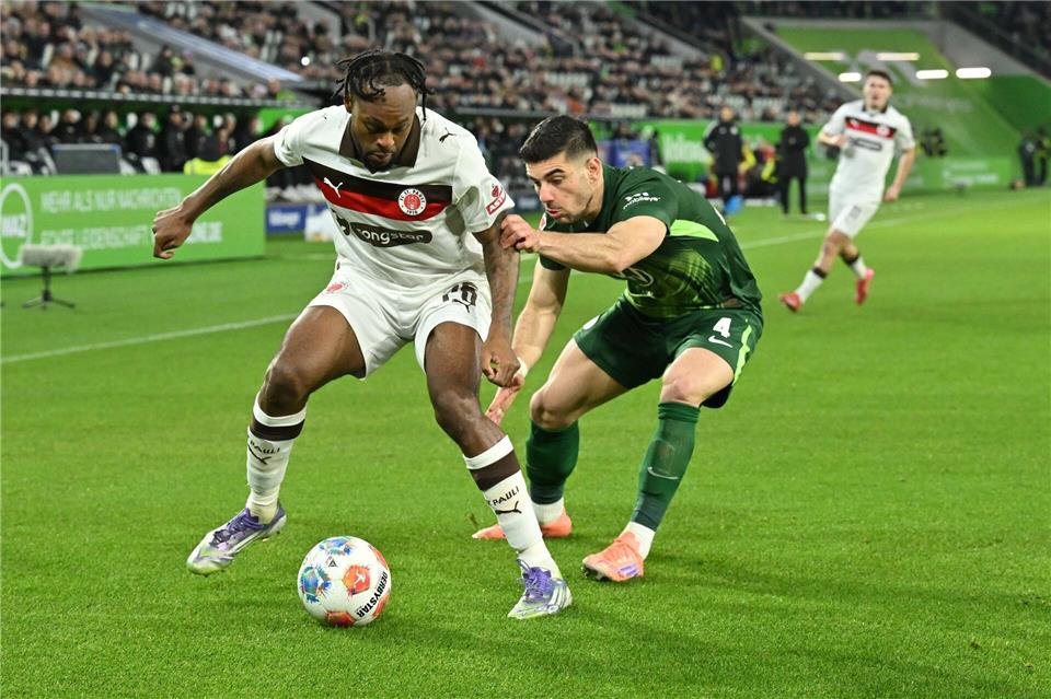 Im Zweikampf: St. Paulis Ricky Jade-Jones (l) und Wolfsburgs Konstantinos Koulierakis.Swen Pförtner/dpa