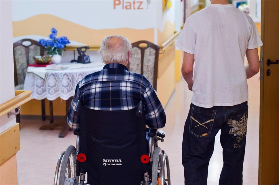 Im einem Seniorenheim betreut ein junger Mann einen Mann im Rollstuhl. (Symbolbild)Patrick Pleul/dpa-Zentralbild/dpa
