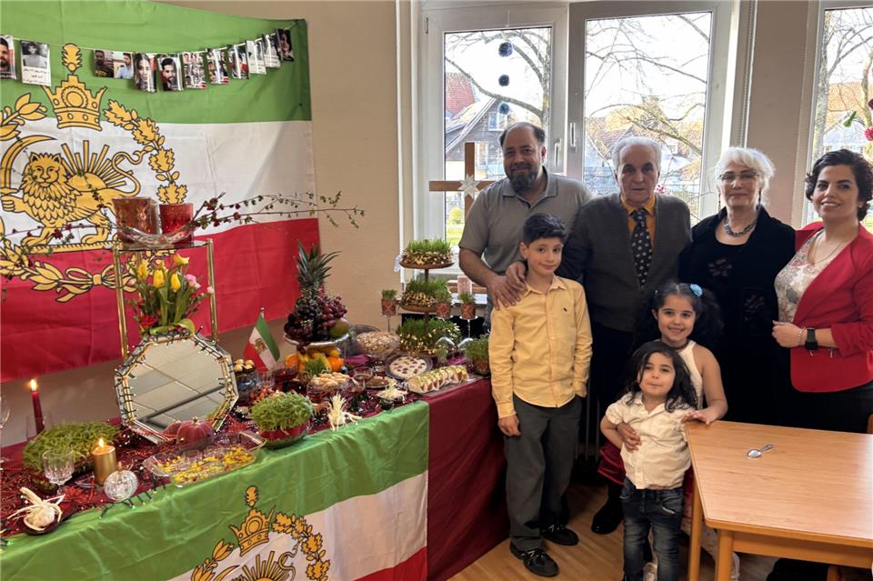 Iman Kousheshrani (hinten links) mit einigen Gästen. Er hat das Nouroz-Fest organisiert, zu dem traditionell eine reich gedeckte Tafel gehört.