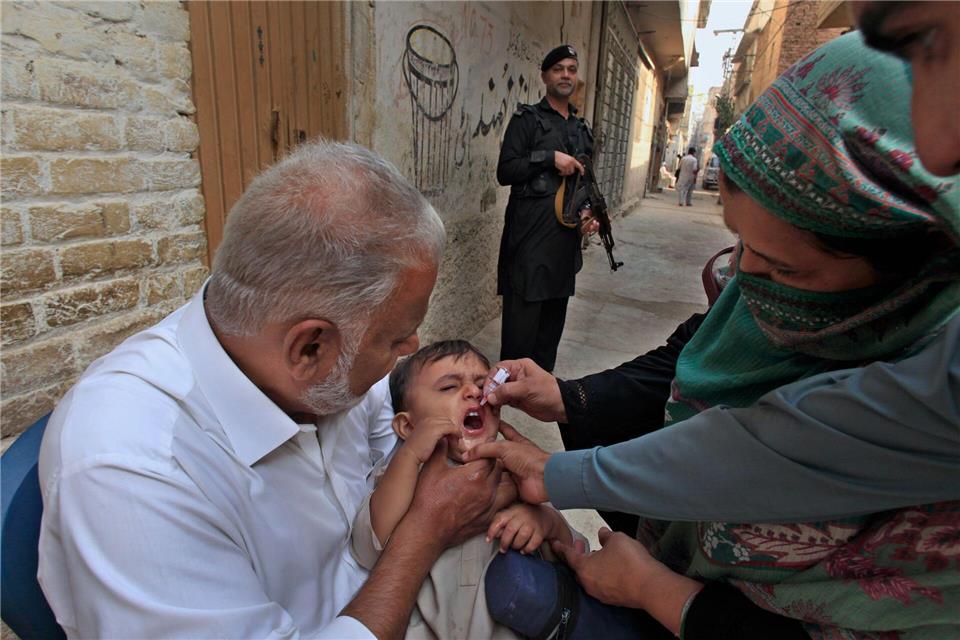 Impf-Teams in Pakistan werden von bewaffneten Männern bewacht, weil sie oft Ziel von Anschlägen sind. (Archivbild)Mohammad Sajjad/AP/dpa
