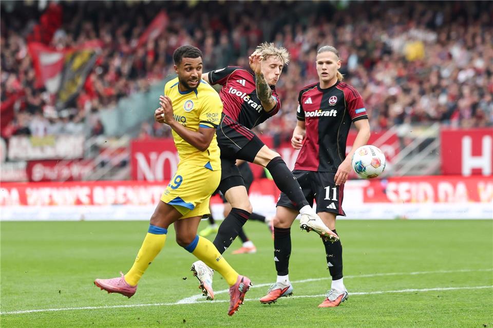 In Aktion: Tim Drexler vom 1. FC Nürnberg (M) und Leon Bell-Bell von Eintracht Braunschweig.Daniel Löb/dpa