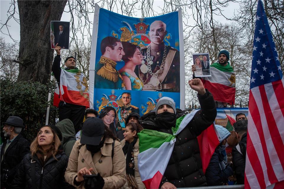 In Fahnen gehüllte iranische Demonstranten skandieren Slogans.Krisztian Elek/SOPA Images via ZUMA Press Wire/dpa
