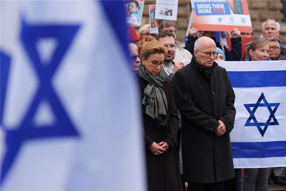 In Hamburg versammeln sich mehrere Menschen zu einer Mahnwache. Marcus Brandt/dpa