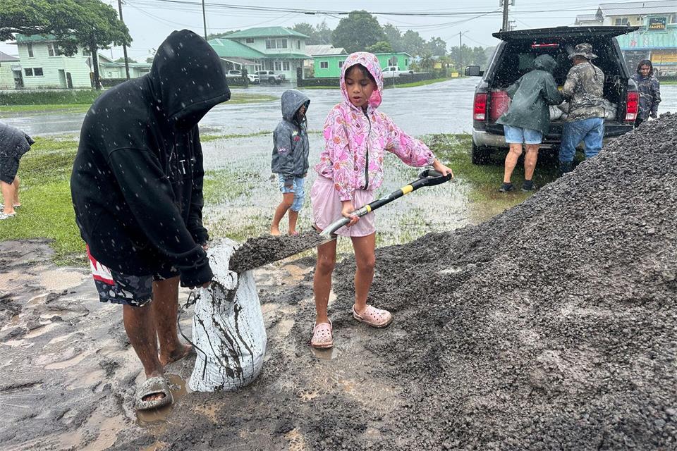 In Hawaii füllen Menschen Sandsäcke, um ihre Häuser vor den Auswirkungen von „Nolo“ zu schützen.Eugene Garcia/AP/dpa