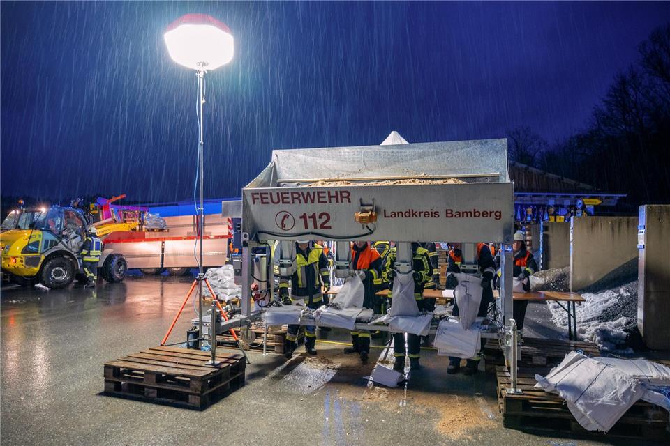 In Schlüsselfeld im Landkreis Bamberg befüllen Feuerwehrleute Sandsäcke.Ferdinand Merzbach/NEWS5/dpa
