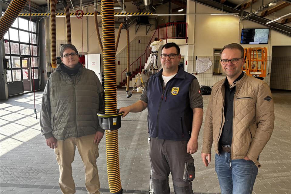 In der Fahrzeughalle der Groß Rekener Feuerwehr laufen die letzten Arbeiten: Jörg Wiesmann (von links), Bernd Niewerth und Thomas Leuderalbert. Im Hintergrund rechts sieht man den Tunnel in die alte Fahrzeughalle.