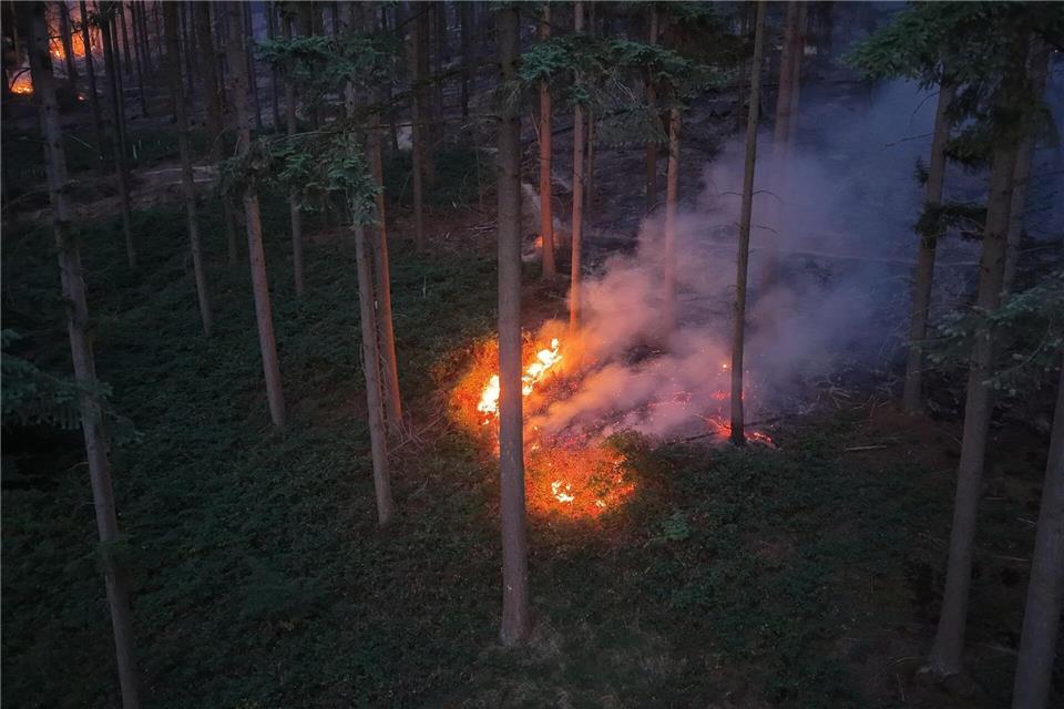 In der Nacht loderten noch Flammen in dem schwer zugänglichen Gebiet. Kevin Schößler/dpa