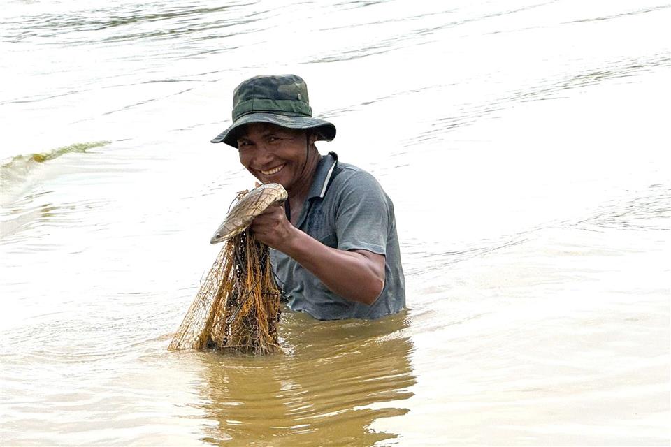 In der Trockenzeit werfen die Fischer ihre Netze aus, während sie hüfttief im Wasser stehen.Carola Frentzen/dpa