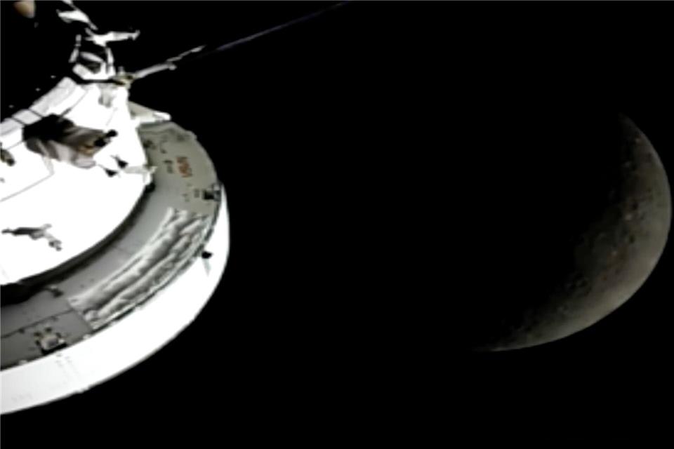 In diesem Bild aus einem von der NASA zur Verfügung gestellten Video sind die „Orion“-Raumkapsel, der Mond und die Erde (r) von einer Kamera aus zu sehen, während die „Artemis 2“-Besatzung und das Raumschiff weiter in den Weltraum vordringen.Uncredited/NASA/dpa