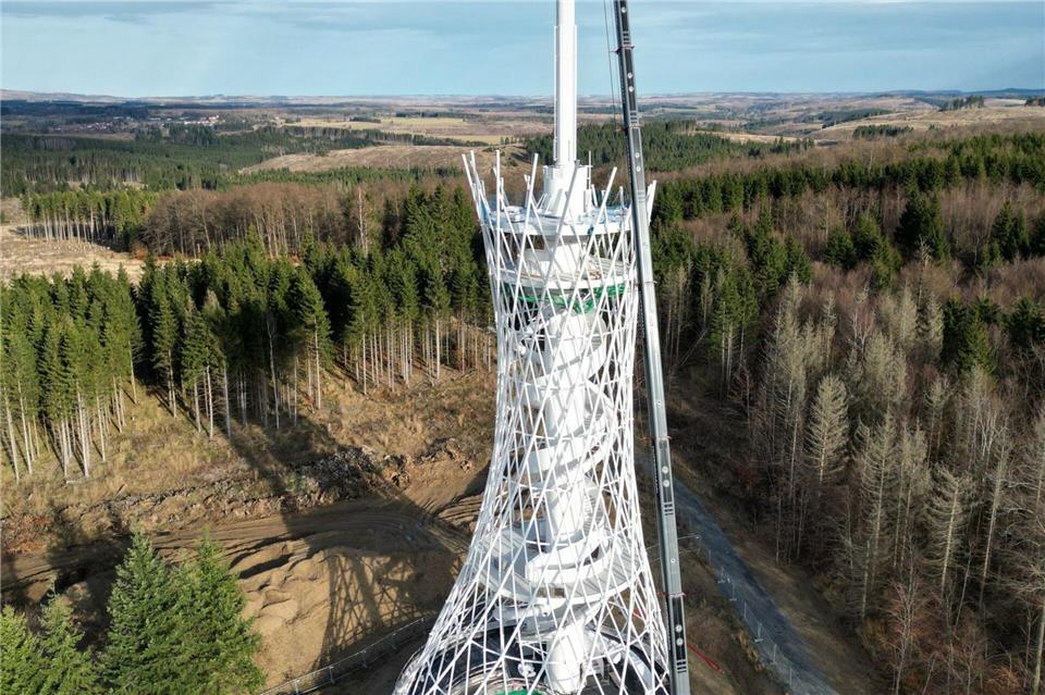 In luftiger Höhe und mit Spezialkran arbeiten die Fachleute an dem Aussichtsturm, der voraussichtlich 2025 fertiggestellt wird.Matthias Bein/dpa