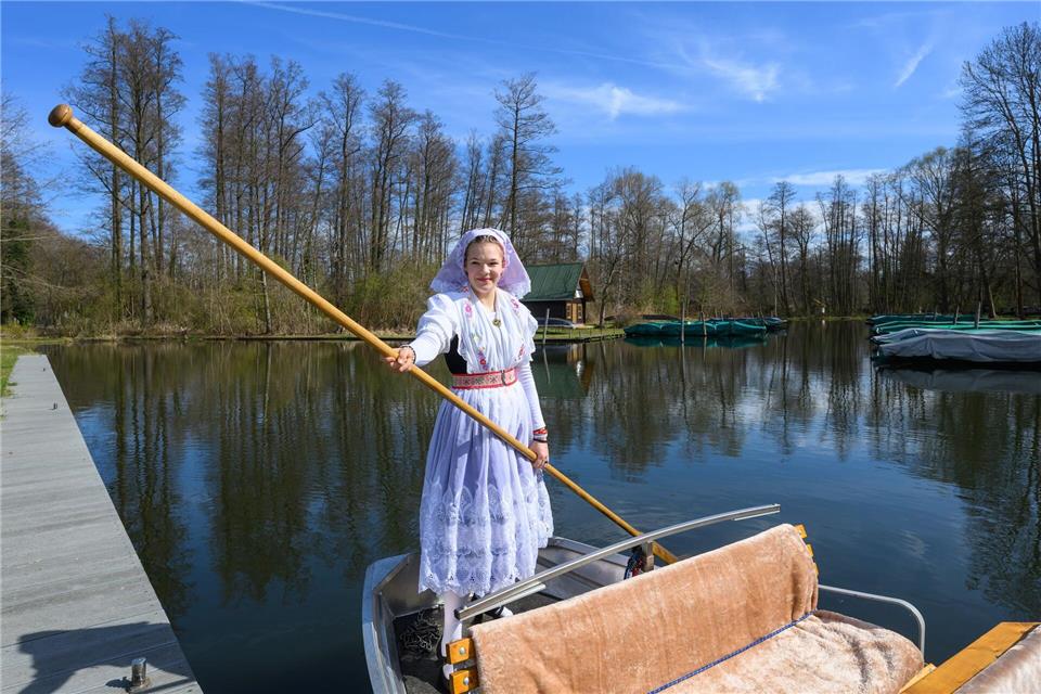 In sorbisch-wendischer Festtagstracht steuert Neele Birkhold einen Kahn. Patrick Pleul/dpa