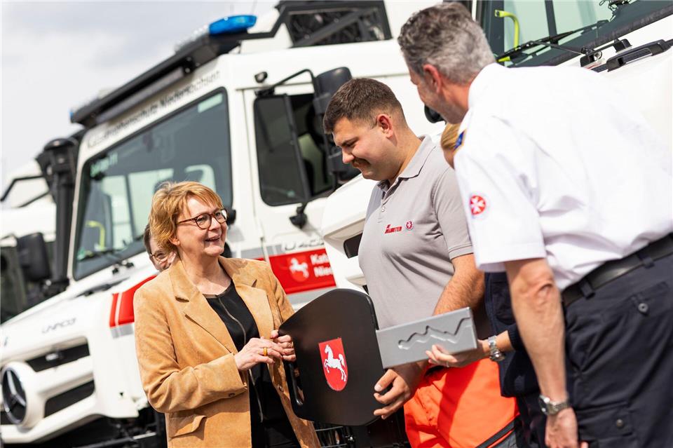 Innenministerin Daniela Behrens (SPD) überreicht symbolisch einen Schlüssel an die Besatzung eines neuen geländegängigen Krankentransportwagens. Michael Matthey/dpa