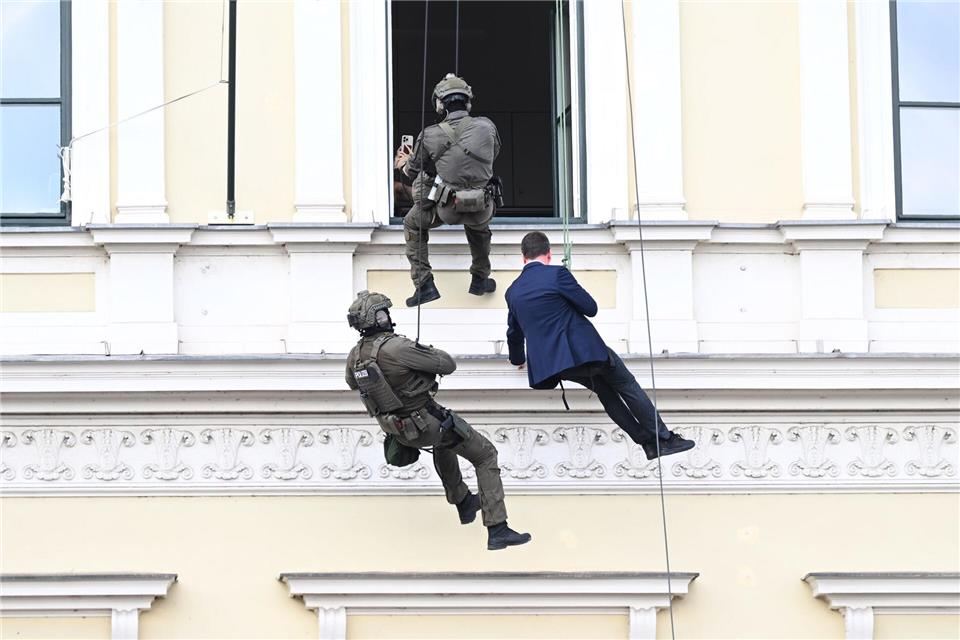 Innenstaatssekretär Sandro Kirchner lässt sich aus dem Fenster des Ministeriums abseilen. Felix Hörhager/dpa