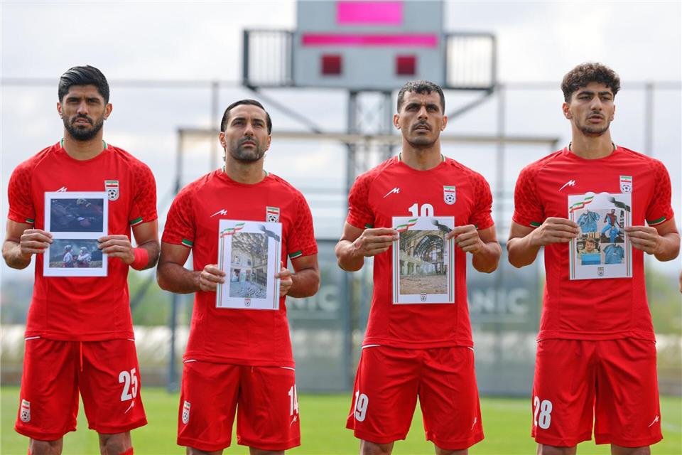 Iranische Nationalspieler zeigen Bilder von Kindern, die bei einem Angriff der USA und Israels auf den Iran getötet worden sein sollen. (Archivbild)Riza Ozel/AP/dpa
