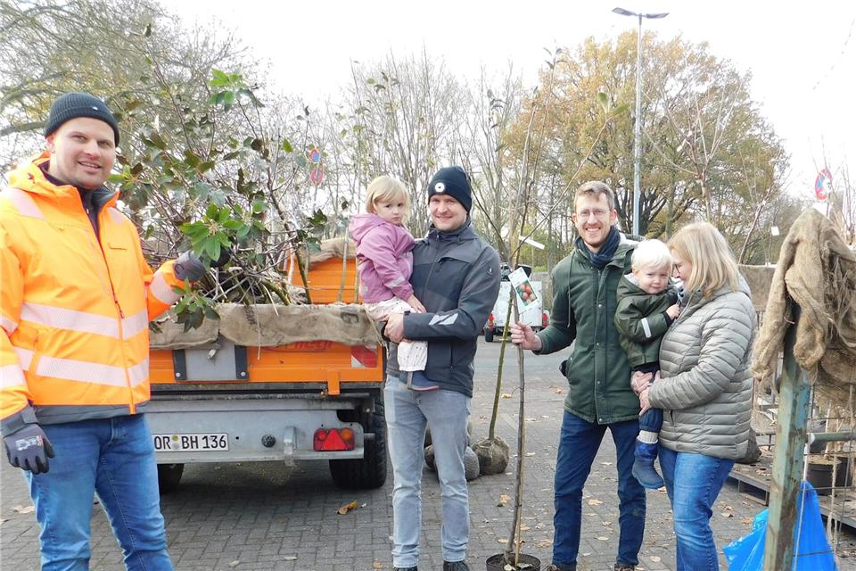 Irene und Stefan Seggewies (von rechts) sowie Michael Ahlte (3. von rechts) mit ihrem Nachwuchs Leni, 3 Jahre, und Theo, 2 Jahre, und Bauleiter Thorben Schulze Dinkelborg beim Verladen der Jubiläumsbäume.