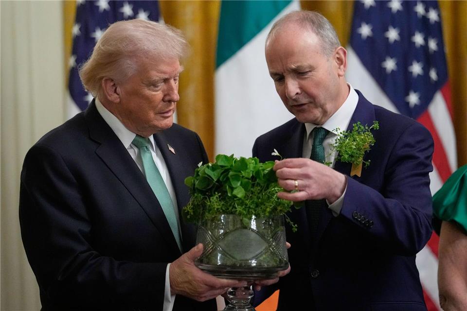 Irlands Premierminister Micheál Martin (r) überreicht US-Präsident Donald Trump eine Schale mit Kleeblättern .Julia Demaree Nikhinson/AP/dpa