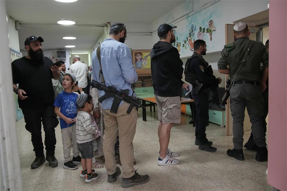Israel-Wahl: Bewaffnete Siedler warten am WahllokalLeo Correa/AP/dpa