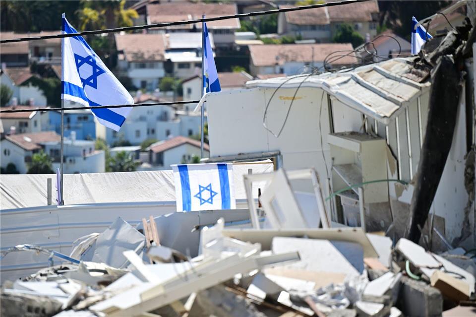 Israelische Fahnen an Ort eines iranischen Raketenangriffs in Beit Schemesch. Sebastian Christoph Gollnow/dpa
