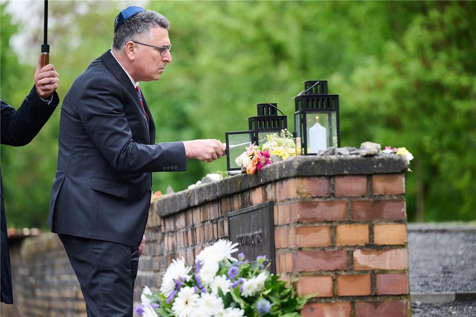 Israels Außenminister Gideon Saar zündet bei seinem Besuch am Mahnmal „Gleis 17“ eine Kerze an.Annette Riedl/dpa