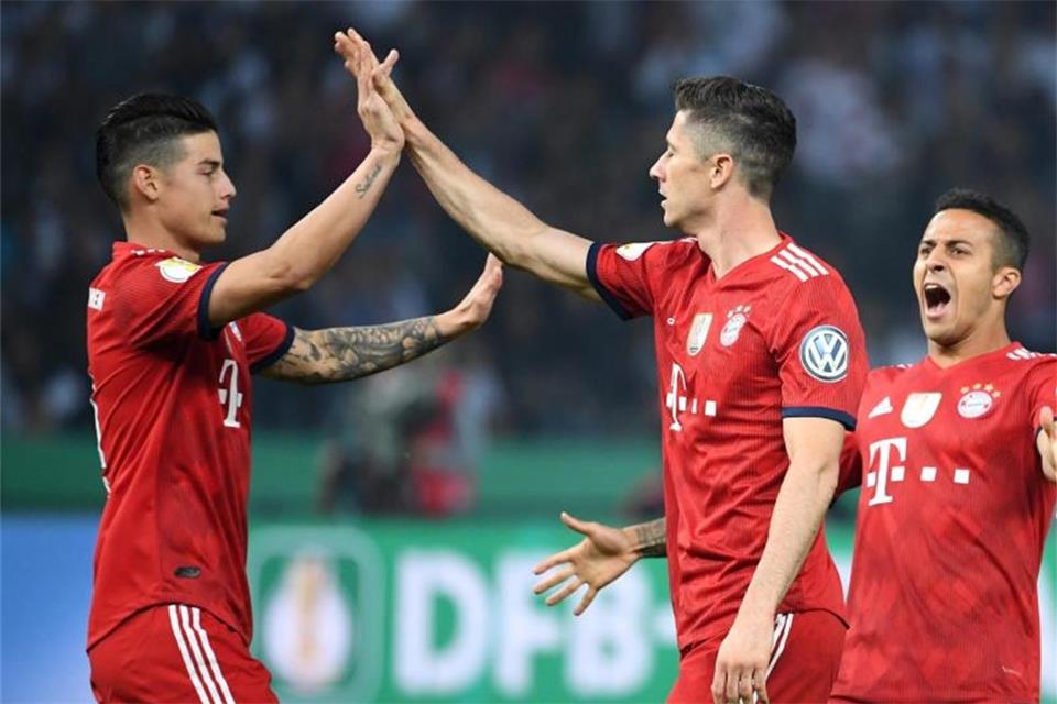 James Rodriguez (l) und Thiago beglückwünschen Robert Lewandowski (M) zu seinem Ausgleichstreffer. Foto: Peter Kneffel