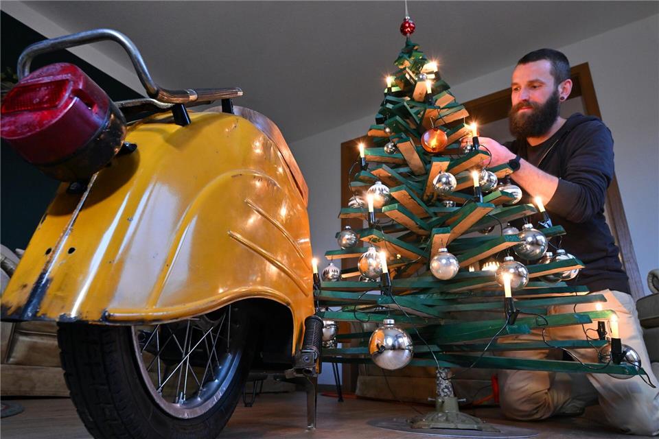 Jan Hofmann schmückt einen Weihnachtsbaum auch mit Weihnachtsbaumkugeln aus Simson-Blinkern.Martin Schutt/dpa