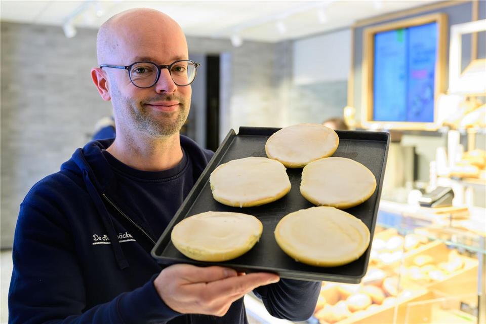Jannik Harms, Geschäftsführer der De Heidbäcker GmbH, hält ein Blech „Grönländer“ in der Hand.Philipp Schulze/dpa