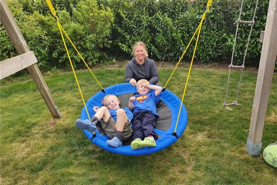 Jessica Vennhoff und ihre Söhne Rico und Joris haben mit der neuen Nestschaukel im Garten Spaß.