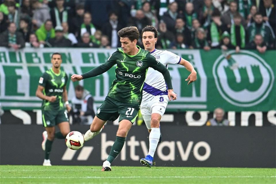 Joakim Maehle vom VfL Wolfsburg wird von dem Osnabrücker Leonhard Münst verfolgt.Swen Pförtner/dpa