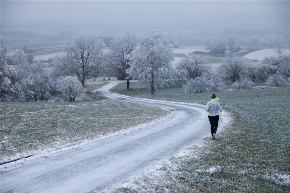 Joggerin trotzt Schnee und Raureif an Heiligabend in UttenweilerThomas Warnack/dpa