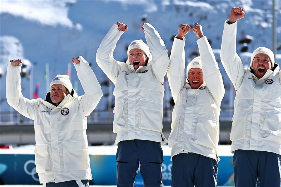 Johannes Hoesflot Klaebo (l) jubelt mit dem Team.Daniel Karmann/dpa