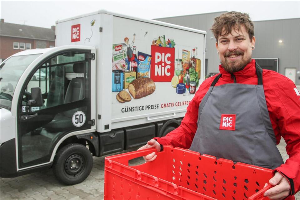 Jonas Allkemper ist Standortleiter in Bocholt. Er steht vor der neuen Halle an der Dingdener Straße und einem der Elektrotransporter von Picnic.Sven Betz