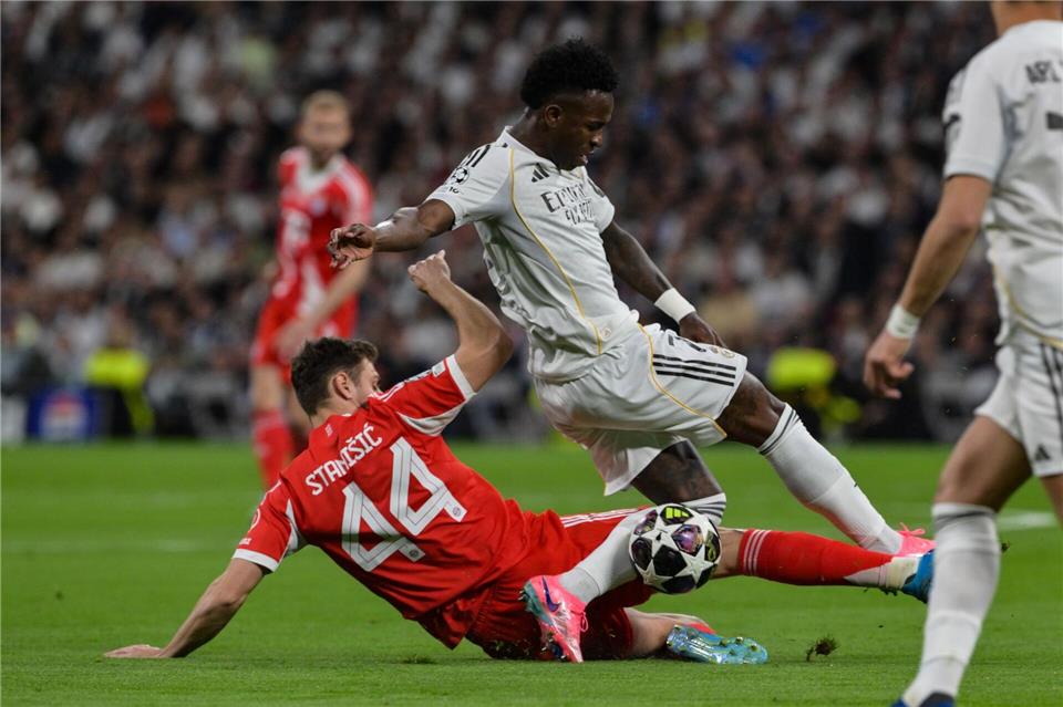 Josip Stanisic (l) bremst Reals Stürmerstar Vinícius Júnior.Peter Kneffel/dpa