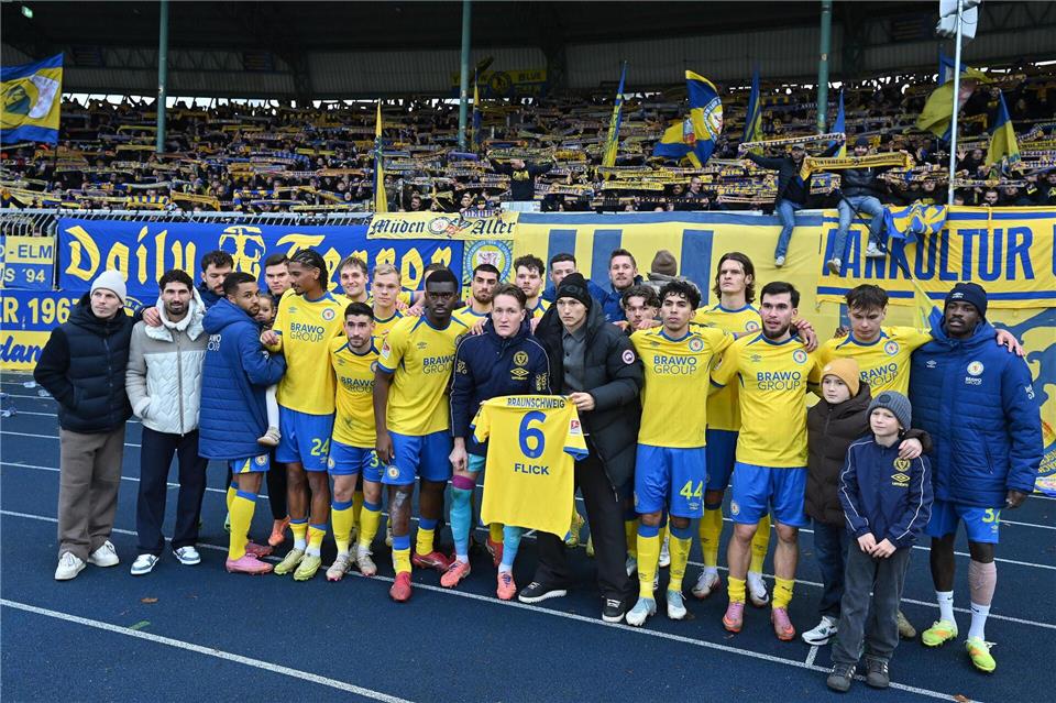 Jubel mit Flick-Trikot: Die Spieler von Eintracht Braunschweig grüßen nach dem 2:0-Sieg gegen Kaiserslautern ihren verletzten Mitspieler.Swen Pförtner/dpa