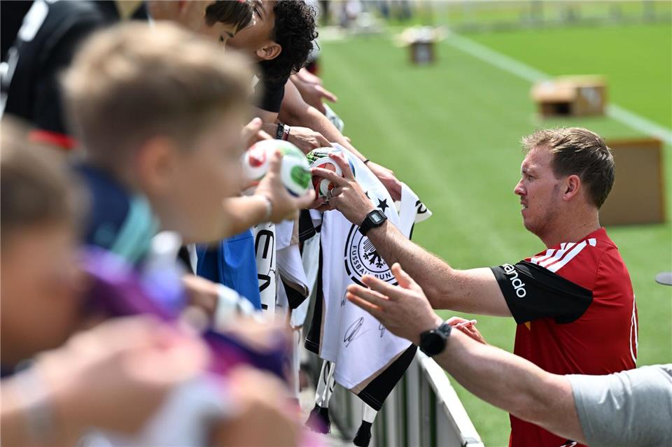 Julian Nagelsmann schreibt Autogramme für Fans der Nationalmannschaft (Archivbild). Federico Gambarini/dpa