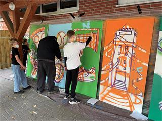 Junge Graffiti-Künstler gestalten bei einem Workshop Platten, die später zu einem großen Ganzen zusammengefügt werden.
