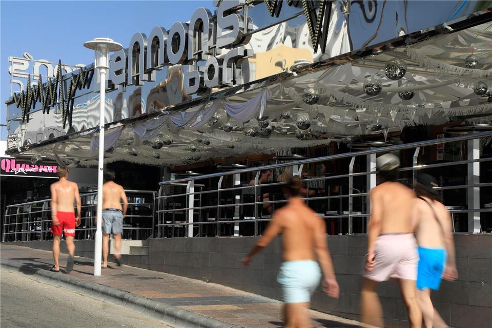 Junge Männer gehen mit nacktem Oberkörper auf Mallorca spazieren. (Archivbild)Clara Margais/dpa