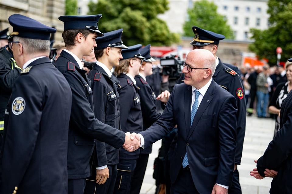 Kai Wegner (CDU), Regierender Bürgermeister von Berlin, gratuliert Feuerwehranwärter der freiwilligen FeuerwehrFabian Sommer/dpa