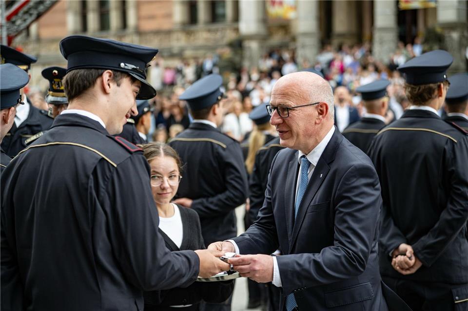 Kai Wegner (CDU,r), Regierender Bürgermeister von Berlin, gratuliert Feuerwehranwärtern der freiwilligen Feuerwehr. Fabian Sommer/dpa