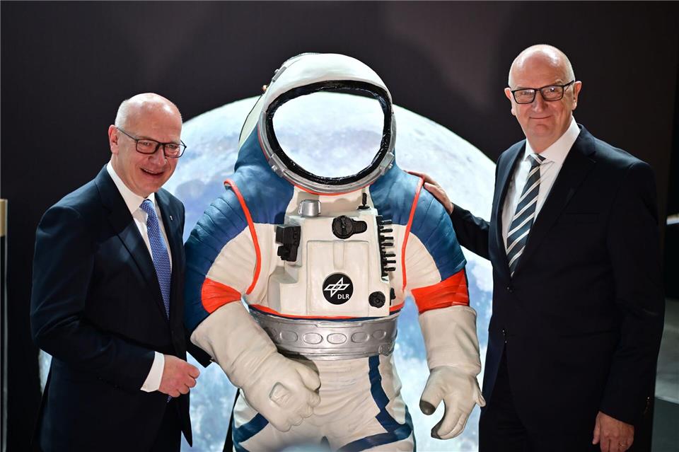 Kai Wegner (l, CDU), Regierender Bürgermeister von Berlin, und Dietmar Woidke (SPD), Ministerpräsident von Brandenburg, stehen neben einem Modell eines Weltraumanzuges.Sebastian Gollnow/dpa