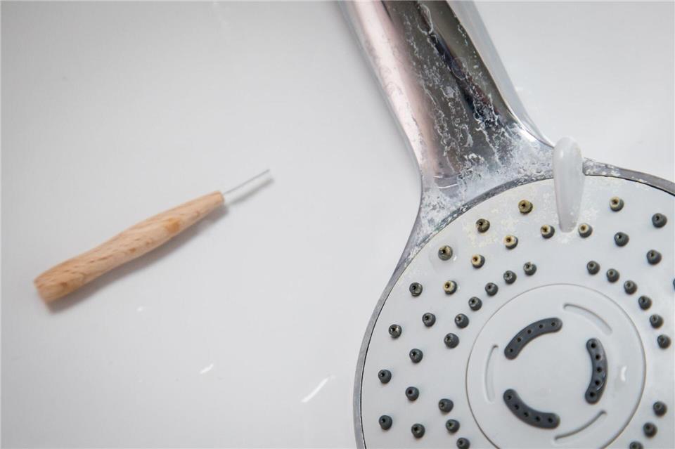 Kalk verstopft die feinen Düsen am Duschkopf und lässt den Wasserstrahl schwächer werden.Christin Klose/dpa-tmn