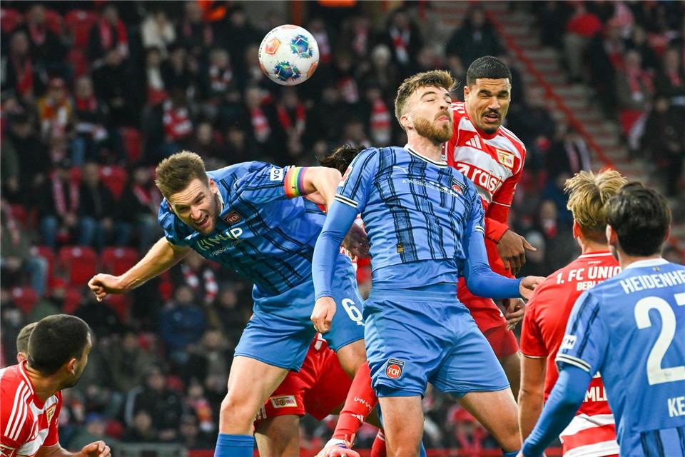 Kampf prägte die Partie. Heidenheims Marvin Pieringer (l) und Niklas Dorsch stoppen Unions Danilho Doekhi.Soeren Stache/dpa