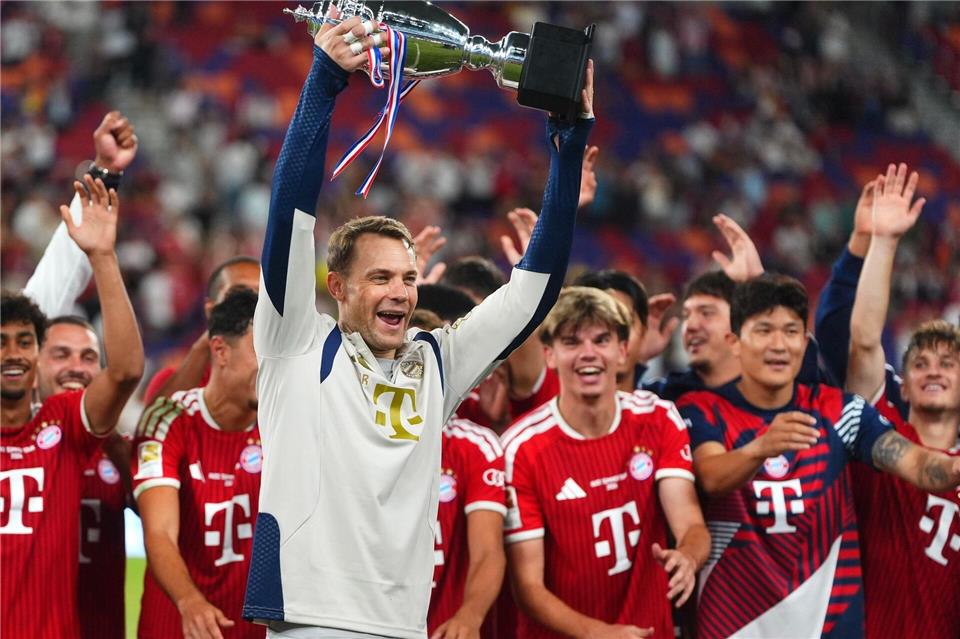 Kapitän Neuer reckt den Pokal in die Höhe.Chan Long Hei/AP/dpa